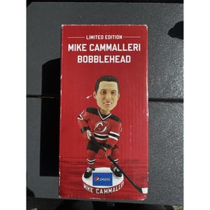 May include: A limited edition Mike Cammalleri bobblehead in a red box. The bobblehead depicts a hockey player in a red and black jersey with the Pepsi logo on the base. The box has the text "LIMITED EDITION" at the top.
