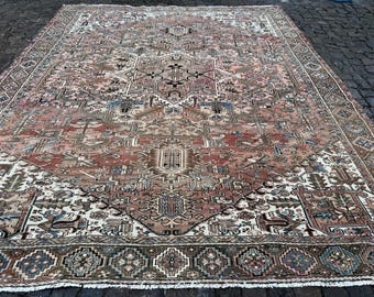 May include: A large, rectangular rug with an intricate, geometric pattern. The rug features a central medallion design in shades of red, brown, and cream, with a dark border. The rug's design includes floral and geometric motifs.