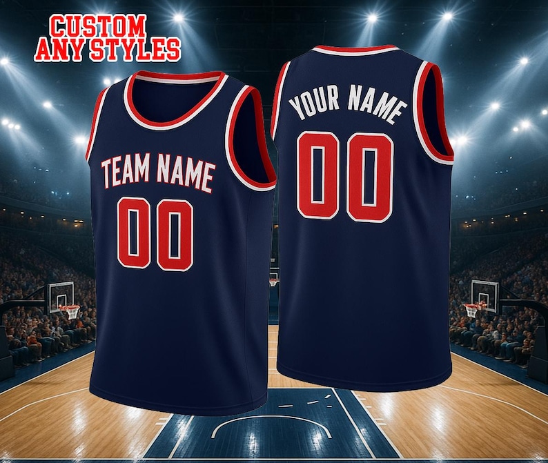 May include: A navy blue basketball jersey with red and white trim. The front features the text TEAM NAME and the number 00 in red with white outlines. The back displays YOUR NAME and the number 00 in white. The text CUSTOM ANY STYLES is visible.