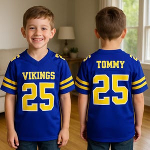 Puede incluir: Una camiseta de f&uacute;tbol azul con detalles amarillos, que muestra "VIKINGS" y el n&uacute;mero "25" en amarillo. La parte trasera muestra el nombre "TOMMY" y el n&uacute;mero "25".