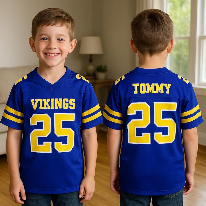Puede incluir: Una camiseta de f&uacute;tbol azul con detalles amarillos, que muestra "VIKINGS" y el n&uacute;mero "25" en amarillo. La parte trasera muestra el nombre "TOMMY" y el n&uacute;mero "25".