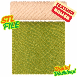Può includere: Un rullo di texture beige con un motivo a scaglie di rettile è mostrato sopra una superficie verde a motivi di scaglie. L'immagine include il testo "STL FILE", "TEXTURE ROLLER" e "Digital Download".