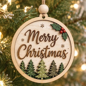 May include: A round wooden Christmas ornament featuring the text Merry Christmas in dark brown script. The design includes green pine trees at the bottom, a sprig of green holly with red berries at the top right, and small star accents.