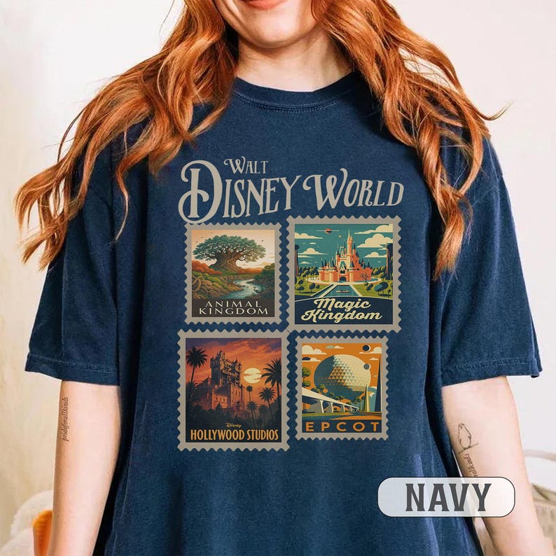 May include: Navy blue t-shirt featuring a Walt Disney World design. The design includes four postage stamp-style images representing Animal Kingdom, Magic Kingdom, Hollywood Studios, and Epcot. The word "NAVY" is printed at the bottom.