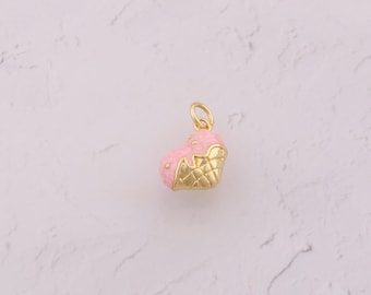 May include: A gold-colored charm in the shape of an ice cream cone. The charm features a pink ice cream scoop with gold-colored drippings and a gold-colored waffle cone base. Small gold-colored dots are on the ice cream.