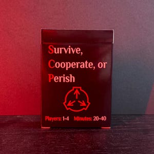 May include: A black card game box with red text that reads "Survive, Cooperate, or Perish." Below the text is a red symbol with three arrows. The bottom of the box reads "Players: 1-4 Minutes: 20-40."