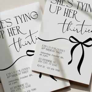 May include: Off-white birthday party invitations with black text. The phrase "She's Tying Up Her Thirties" is written in a stylish font. A black bow graphic is featured. Includes party details.