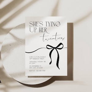 Op de afbeelding: Een minimalistische uitnodigingskaart met de tekst "She's Tying Up Her Twenties" in zwart script. Een zwarte strik-afbeelding is gecentreerd onder de tekst. De kaart bevat feestdetails. Het ontwerp staat tegen een neutrale achtergrond.