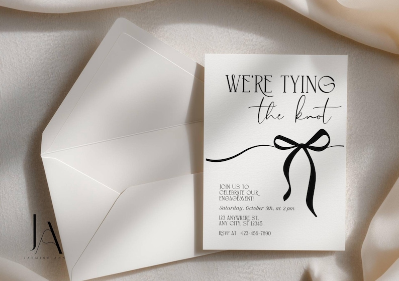 Puede incluir: Una tarjeta de invitaci&oacute;n de compromiso blanca con su sobre a juego. La tarjeta presenta el texto en negro WE'RE TYING the knot, seguido de los detalles del evento incluyendo fecha, hora y lugar, y un gr&aacute;fico negro de un lazo.
