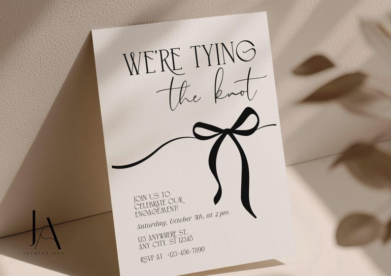 Puede incluir: Una tarjeta de invitaci&oacute;n de compromiso color crema con el texto negro WE'RE TYING the knot y un gr&aacute;fico de lazo negro. La tarjeta incluye los detalles: JOIN US TO CELEBRATE OUR ENGAGEMENT! Saturday, October 5th, at 2 pm, 123 ANYWHERE ST. ANY CITY, ST 12345, RSVP AT -123-456-7890.