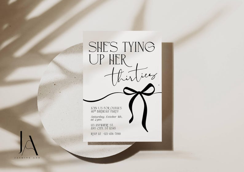 May include: A white invitation card with the text "SHE'S TYING UP HER thirties" in black script. A black bow graphic is below the text. The invitation is for a 40th birthday party.