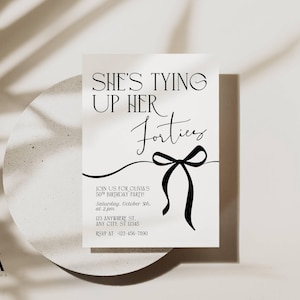 Puede incluir: Una tarjeta de invitación blanca con texto negro y una ilustración de lazo. El texto dice "She's Tying Up Her Forties" e incluye detalles de la fiesta. La tarjeta está sobre un fondo neutro con sombras.