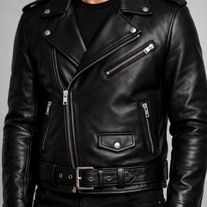 May include: Black leather motorcycle jacket with silver zippers, a snap-down lapel, and a belted waist. The jacket features multiple pockets and a classic asymmetrical design. A stylish outerwear piece.