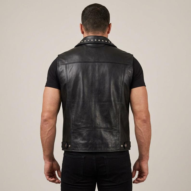 May include: Black leather vest with a studded collar and a classic design. The vest has a button closure and a tailored fit. A stylish and edgy piece of outerwear.