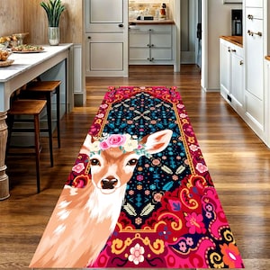 May include: A long rectangular runner rug featuring a central illustration of a deer with a floral crown on its head. The rug has a dark blue background with a vibrant red and pink decorative border containing intricate floral and geometric patterns.