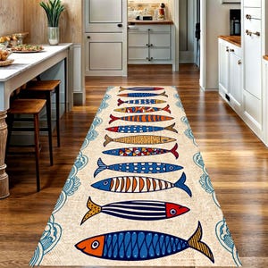 May include: A rectangular beige runner rug with a repeating pattern of colorful fish. The fish designs include blue, orange, red, and yellow, with various patterns. The rug has a decorative blue border and is placed on a wooden floor.