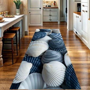Peut inclure: Un long tapis de couloir rectangulaire présentant un motif répétitif de divers coquillages dans des tons bleu marine profond, gris ardoise et blanc éclatant. Le design affiche une disposition dense de coquilles Saint-Jacques superposées.