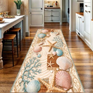 May include: A long rectangular runner rug featuring a coastal design with various seashells, starfish, and coral branches in shades of blue, pink, and tan. The pattern includes textured woven sections and a decorative border on a sandy background.