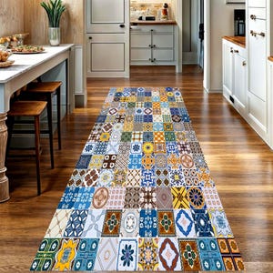 Peut inclure: Un tapis rectangulaire à motifs avec un design patchwork de divers carreaux géométriques et floraux dans des tons de bleu, jaune, marron et blanc. Le tapis est posé sur un sol en bois dans un couloir.