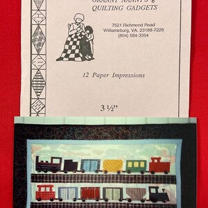 May include: A quilting pattern titled "Granny Nanny's Quilting Gadgets" with a train design. The pattern includes a picture of a train with various colored train cars. The pattern is 3.5 inches wide.