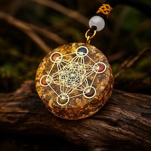 Op de afbeelding: Een ronde hanger met een gouden geometrisch ontwerp en ingebedde kleurrijke stenen. De hanger hangt aan een zwart koord met een gouden sluiting en een witte kraal. De hanger heeft een bruin en goud gespikkeld achtergrond.