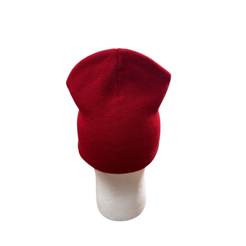 Puede incluir: Un gorro de punto rojo s&oacute;lido con una corona simple y redondeada y una textura suave y uniforme. El gorro presenta un dise&ntilde;o cl&aacute;sico de poner con un borde doblado en la base, construido con una tela suave y flexible que mantiene su forma.
