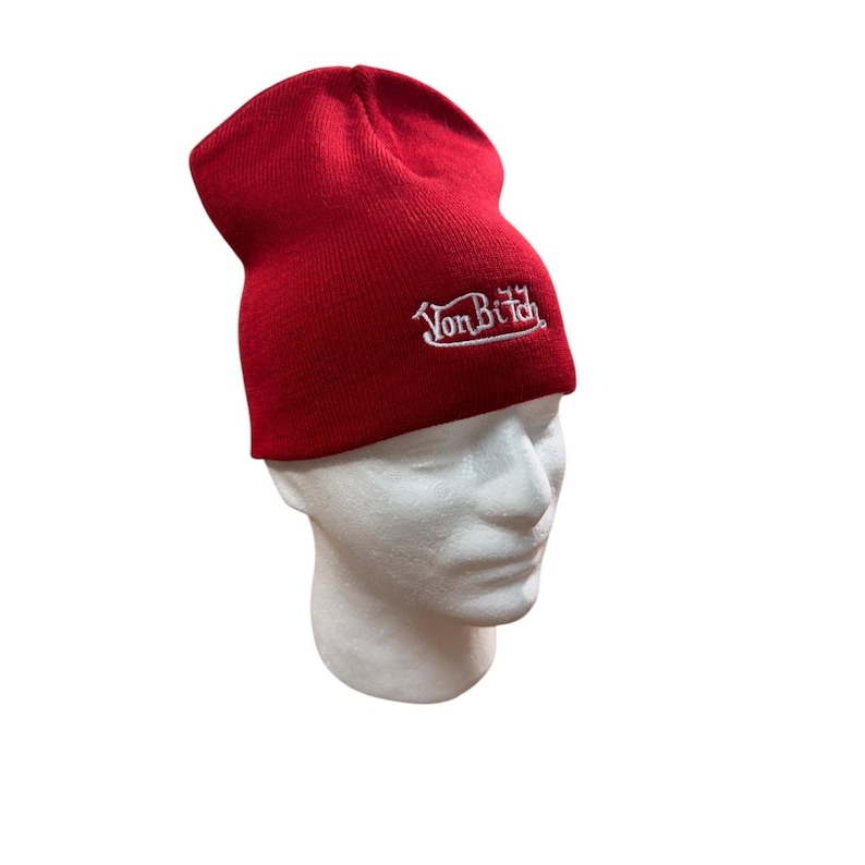 Puede incluir: Un gorro de punto de color rojo brillante con el texto VonBitch bordado en hilo blanco en la parte delantera. El gorro tiene un dise&ntilde;o cl&aacute;sico con dobladillo y se muestra sobre una cabeza de maniqu&iacute; blanca para ver su forma y ajuste.
