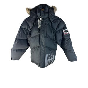 May include: Black puffer jacket with a hood trimmed with faux fur. Features a graphic of a person's face on the lower front and a patch with the letter "M" on the upper arm. Includes a tag.