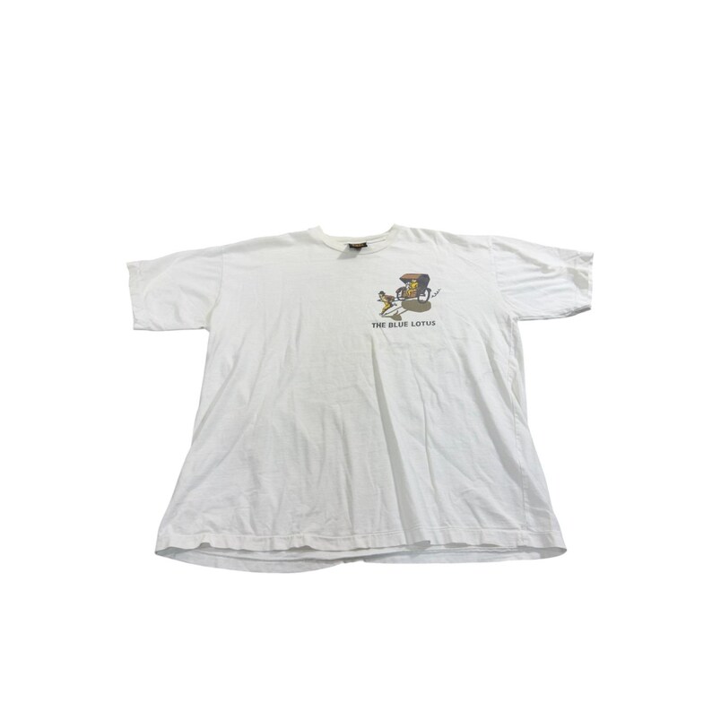 Op de afbeelding: Wit T-shirt met een afbeelding van een persoon in een koets die door een hond wordt getrokken. De tekst "THE BLUE LOTUS" staat onder de afbeelding. Het shirt heeft korte mouwen en een ronde hals.