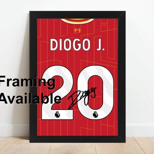 May include: Framed print of a red football jersey with the name "DIOGO J." and the number "20" in white. The jersey features a signature and the Premier League logo. The words "Framing Available" are printed on the left side.