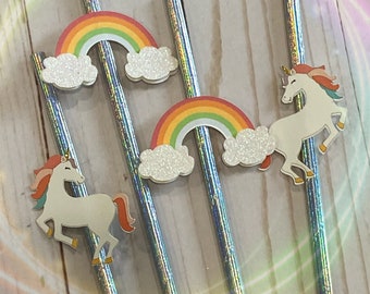 Può includere: Quattro cannucce argentate iridescenti con decorazioni a forma di arcobaleno e unicorno. Le decorazioni a forma di arcobaleno hanno una nuvola bianca su ogni lato. Le decorazioni a forma di unicorno sono bianche con una criniera e una coda rosa.
