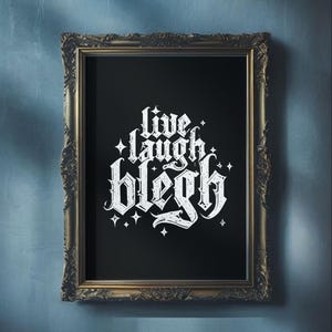 Könnte beinhalten: Ein gerahmter Druck mit schwarzem Hintergrund und weißem Text, der in gotischer Schrift "live laugh bleg" lautet. Der Text ist von kleinen weißen Sternen umgeben.