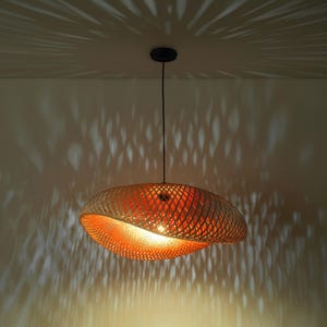 Handgemaakte vintage bamboe hanglamp met een geweven lampenkap in de vorm van een donut.