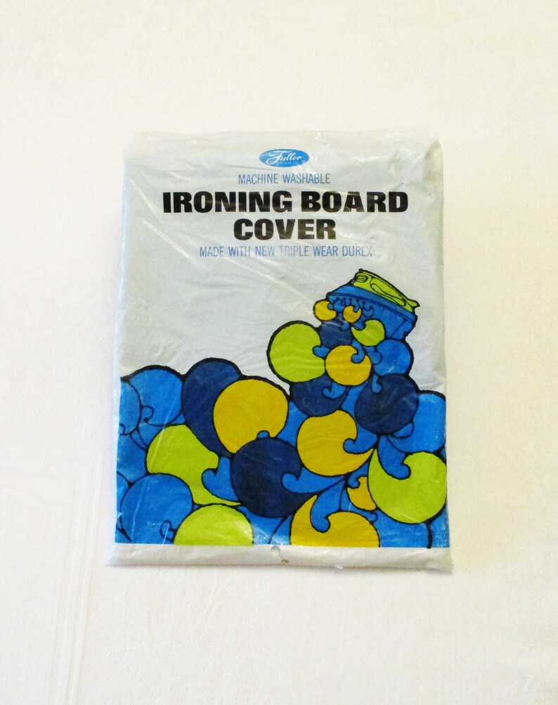 Pode incluir: Uma capa de t&aacute;bua de engomar embalada com o texto "Ironing Board Cover" em letras pretas em negrito. A capa tem um design abstrato azul, amarelo e verde. A embalagem diz "Machine Washable" e "Made with New Triple Wear Durex."