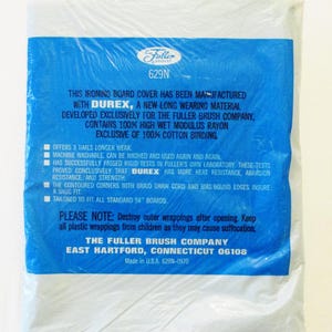 Pode incluir: Uma capa para t&aacute;bua de engomar embalada com uma etiqueta azul. A etiqueta apresenta o log&oacute;tipo da Fuller Brush Company e informa&ccedil;&otilde;es sobre o produto, incluindo o uso do material Durex e sua resist&ecirc;ncia ao calor e &agrave; abras&atilde;o. A capa &eacute; projetada para t&aacute;buas padr&atilde;o de 137 cm.