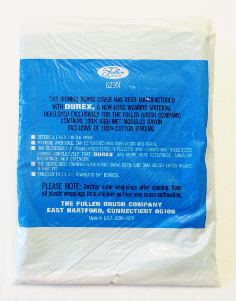 Pode incluir: Uma capa para t&aacute;bua de engomar embalada com uma etiqueta azul. A etiqueta apresenta o log&oacute;tipo da Fuller Brush Company e informa&ccedil;&otilde;es sobre o produto, incluindo o uso do material Durex e sua resist&ecirc;ncia ao calor e &agrave; abras&atilde;o. A capa &eacute; projetada para t&aacute;buas padr&atilde;o de 137 cm.