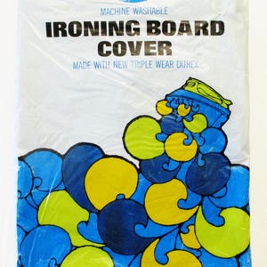 Pode incluir: Uma capa de t&aacute;bua de engomar branca em embalagem pl&aacute;stica. A capa tem um design abstrato azul, amarelo e verde. O texto na embalagem diz "Capa para t&aacute;bua de engomar" e "Lav&aacute;vel na m&aacute;quina."