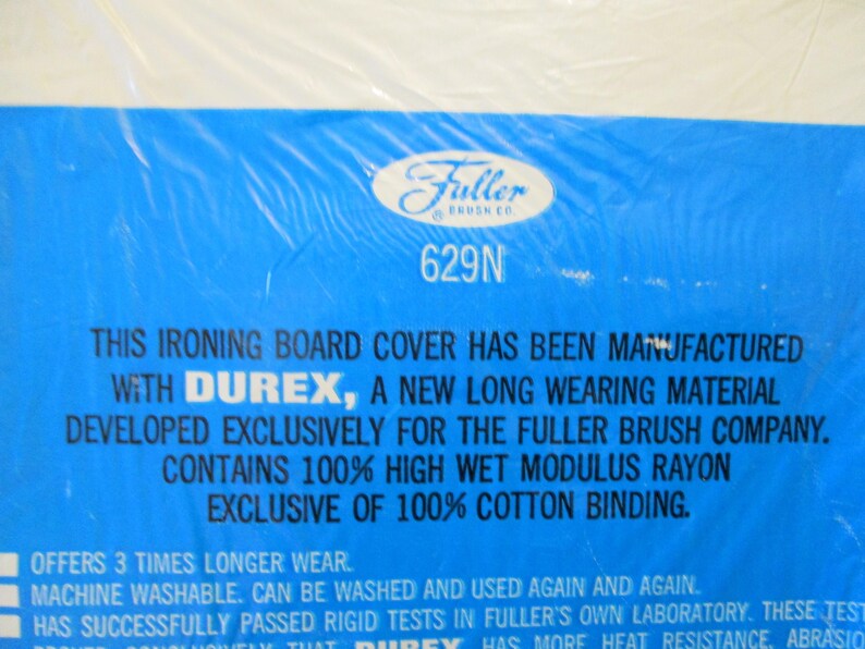 Pode incluir: Embalagem azul de capa para t&aacute;bua de engomar com o log&oacute;tipo Fuller Brush Co. e informa&ccedil;&otilde;es do produto. O texto inclui "Durex" e "100% High Wet Modulus Rayon".