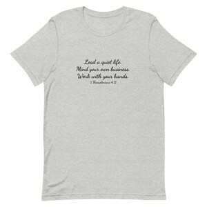 Puede incluir: Una camiseta gris jaspeada con texto negro que dice "Lead a quiet life. Mind your own business. Work with your hands. 1 Thessalonians 4:11"