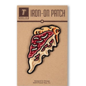May include: Iron-on patch featuring a cartoon slice of pizza with red pepperoni, melted cheese, and a dripping crust. The patch is on a brown card with the text "IRON-ON PATCH" and "Transit Tees" in white.
