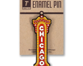 May include: A red and yellow enamel pin featuring a vintage-style sign with the word "CHICAGO" in white letters. The pin is on a brown card with the text "T Enamel Pin Transit Tees" and "Designed and Manufactured in Chicago, Inc."