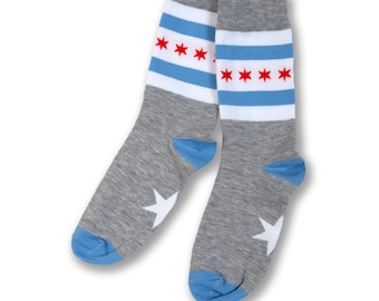 May include: A pair of gray socks with blue and white stripes and red stars. The socks have a white star on the heel.