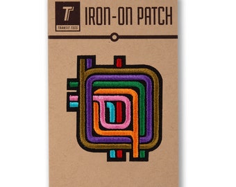 May include: Iron-on patch featuring a colorful abstract design with multiple concentric circles in shades of green, orange, purple, pink, and blue. The patch is on a brown card with the text "T IRON-ON PATCH TRANSIT TEES Designed in Chicago ©2016 Transit Tees, Inc."