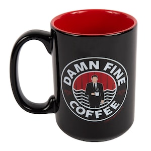 May include: Black ceramic coffee mug with a red interior. The mug features a white circle with the text "DAMN FINE COFFEE" and a silhouette of a man in a suit holding a cup of coffee. The background of the circle is red with white stripes and black wavy lines.