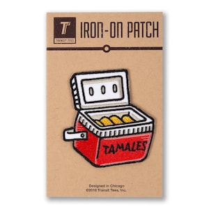 May include: Red and white cooler with the word "TAMALES" on the front. The cooler is open and filled with yellow tamales. The cooler is on a brown background with the text "IRON-ON PATCH" and "TRANSIT TEES" above it.
