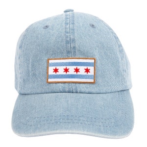 May include: A light blue denim baseball cap with a patch featuring the Chicago flag. The flag has four red stars on a white stripe with two blue stripes.