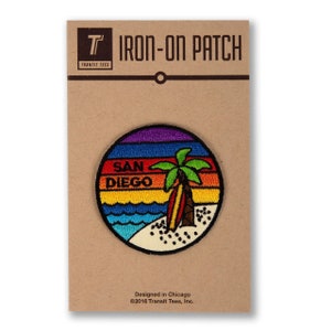 May include: A round iron-on patch with a rainbow sunset design, a palm tree, a surfboard, and the text "SAN DIEGO".