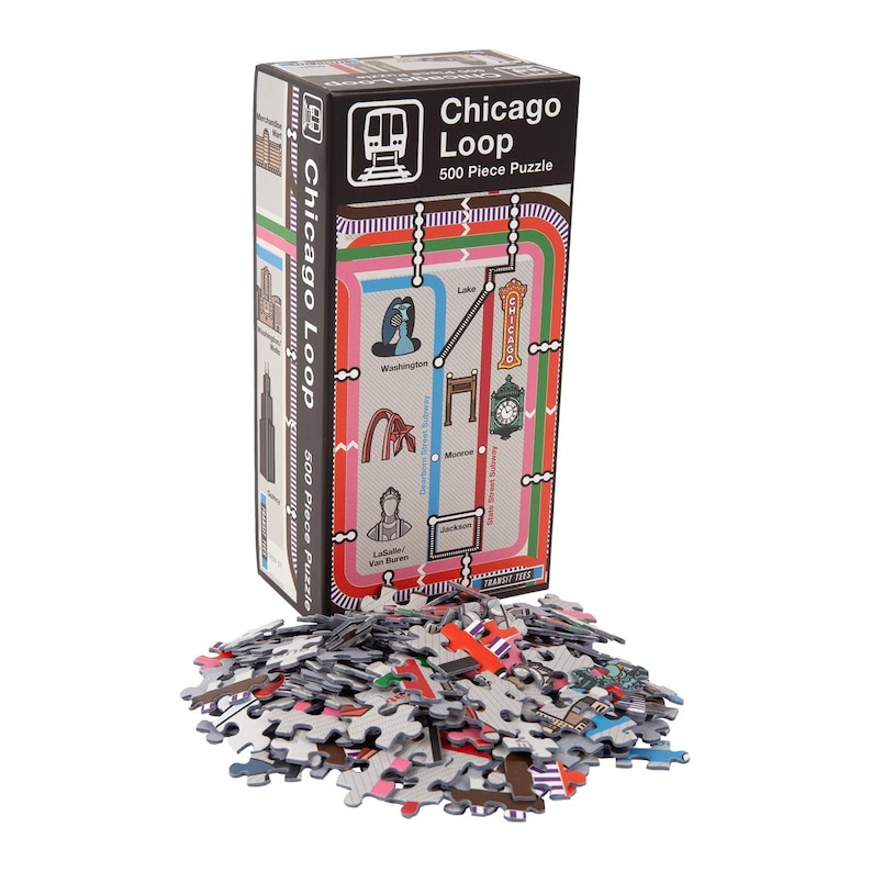 Op de afbeelding: Een 500-delige puzzel van het Chicago Loop 'L' treinsysteem. De doos toont een kleurrijke kaart van de treinlijnen met bezienswaardigheden en de tekst "Chicago Loop 500 Piece Puzzle".