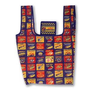 May include: A blue reusable grocery bag with a colorful pattern of Chicago-themed food items, including hot dogs, pizza, gyros, and Italian beef. The bag has a pocket on the front with the text "Love is in the air, only in Chicago" and a logo that says "Save Chicago".