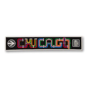 May include: A black and white rectangular sign with the word "CHICAGO" spelled out in colorful lines that resemble a subway map. A gray arrow pointing to the right and a gray beer mug icon are on either end of the sign.